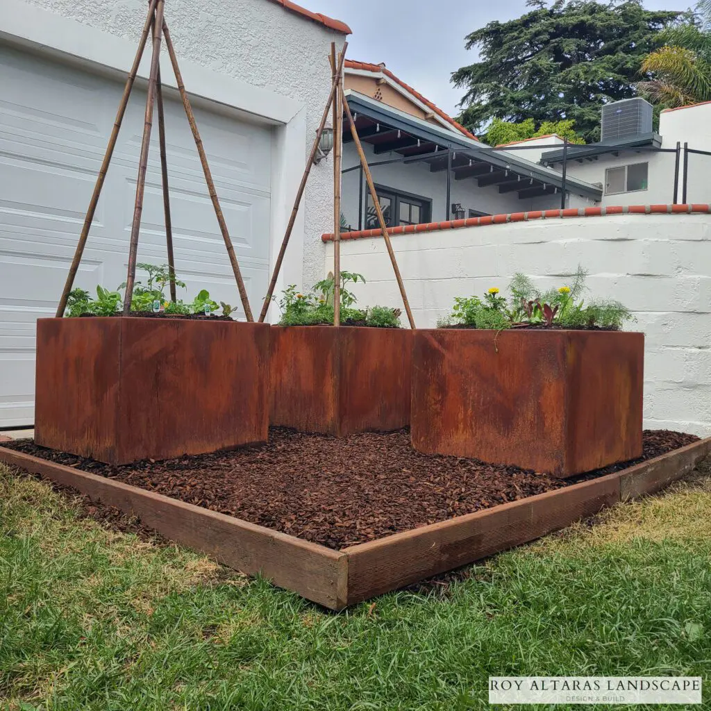 corten steel planters in a raised bed
